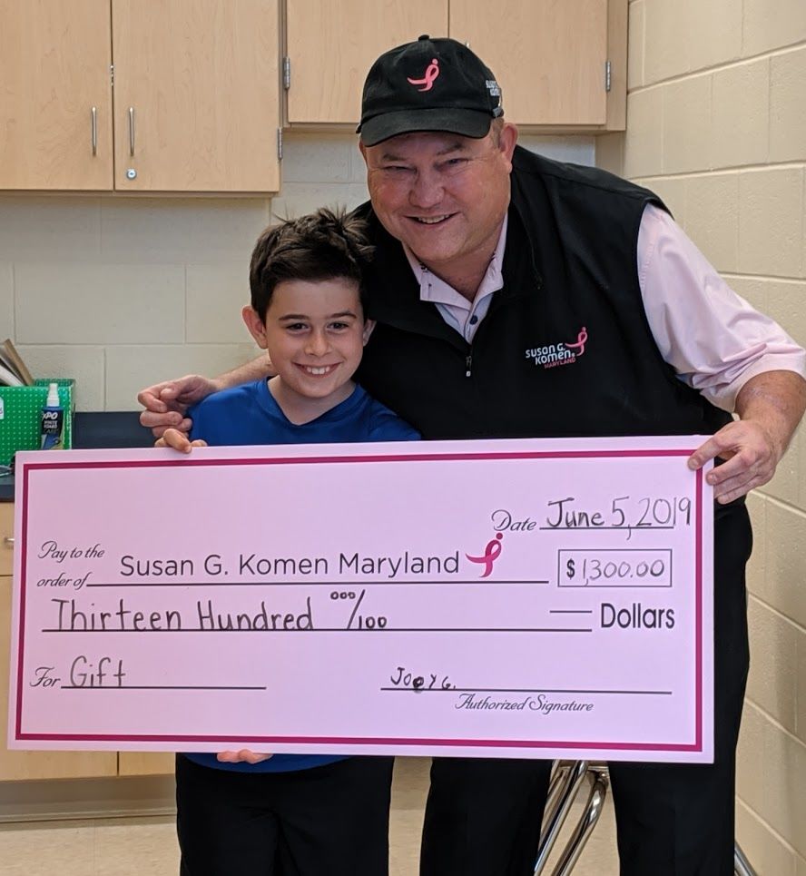 Susan G. Komen's Michael Jessup surprises Joey Goldberg with a check he could sign and give back to the foundation. Goldberg raised $1,300 to fight cancer. (Courtesy Aaron Goldberg)
