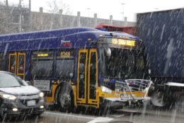 A King County Metro bus displays a snow route sign, Monday, Feb. 11, 2019, in Seattle. Schools were closed across Washington state as winter snowstorms continued pummeling the Northwest. Seattle's metro area has already been hit by three snowstorms in February, making it the snowiest month in Seattle in more than 30 years. (AP Photo/Ted S. Warren)