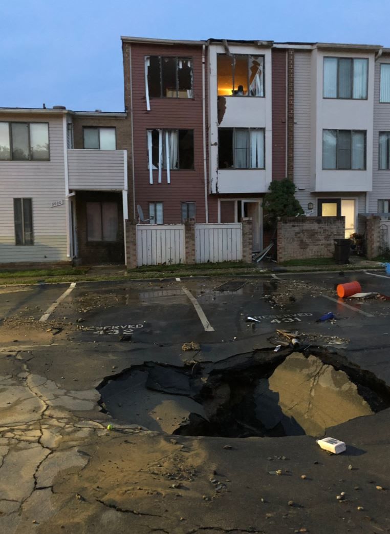 A water main break opens up a sinkhole in a town house complex in Montgomery County, Maryland, on Thursday, June 6, 2019.  (Courtesy Montgomery County Fire and Rescue Service)