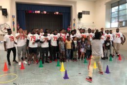 University of Maryland football players cheer with students at J.C. Nalle Elementary to celebrate Jordan McNair. (WTOP/Michelle Basch)