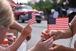 Miniature American Flags were passed out by a number of the marching units in the Takoma Park Fourth of July parade. (WTOP/Kate Ryan)