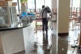 A worker walks through a flooded restaurant