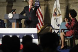 Vice President Mike Pence, points to new naturalized citizens while speaking at a naturalization ceremony in celebration of Independence Day at the National Archives in Washington, Thursday, July 4, 2019. Also on stage is Secretary of Transportation Elaine Chao, right seated. (AP Photo/Pablo Martinez Monsivais)