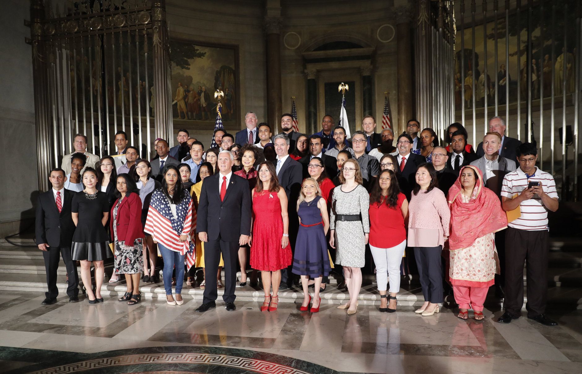 Vice President Mike Pence, center, his wife Karen Pence, pose for a group photo with new naturalized citizens following a naturalization ceremony in celebration of Independence Day at the National Archives in Washington, Thursday, July 4, 2019. Standing behind the Vice President are Secretary of Transportation Elaine Chao and Acting Director, US Immigration and Immigration Services, Kenneth T. Cuccinelli. (AP Photo/Pablo Martinez Monsivais)