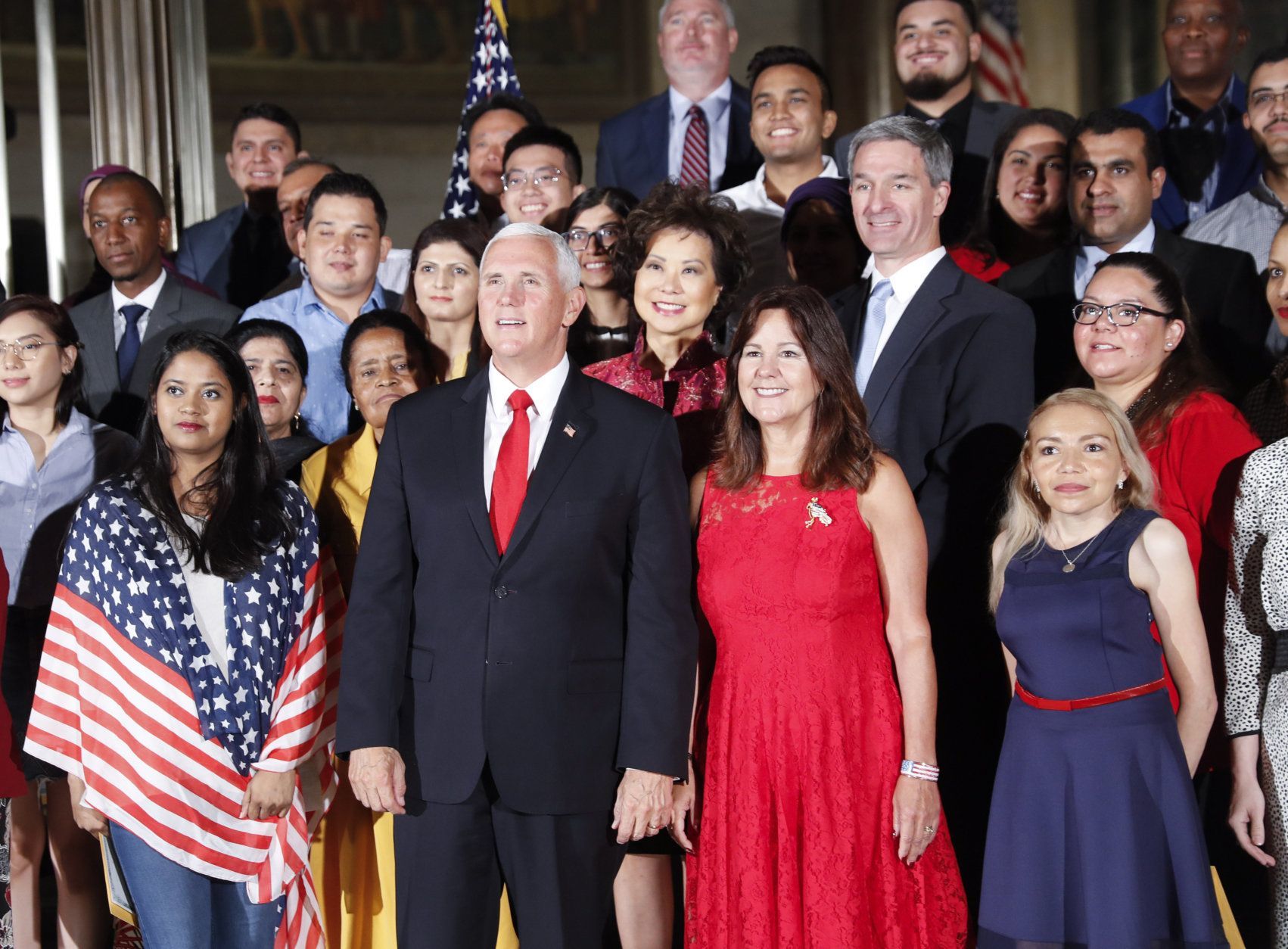 Vice President Mike Pence, center, his wife Karen Pence, to his right, pose for a group photo with new naturalized citizens following a naturalization ceremony in celebration of Independence Day at the National Archives in Washington, Thursday, July 4, 2019. Standing behind the Vice President are Secretary of Transportation Elaine Chao and Acting Director, US Immigration and Immigration Services, Kenneth T. Cuccinelli. (AP Photo/Pablo Martinez Monsivais)