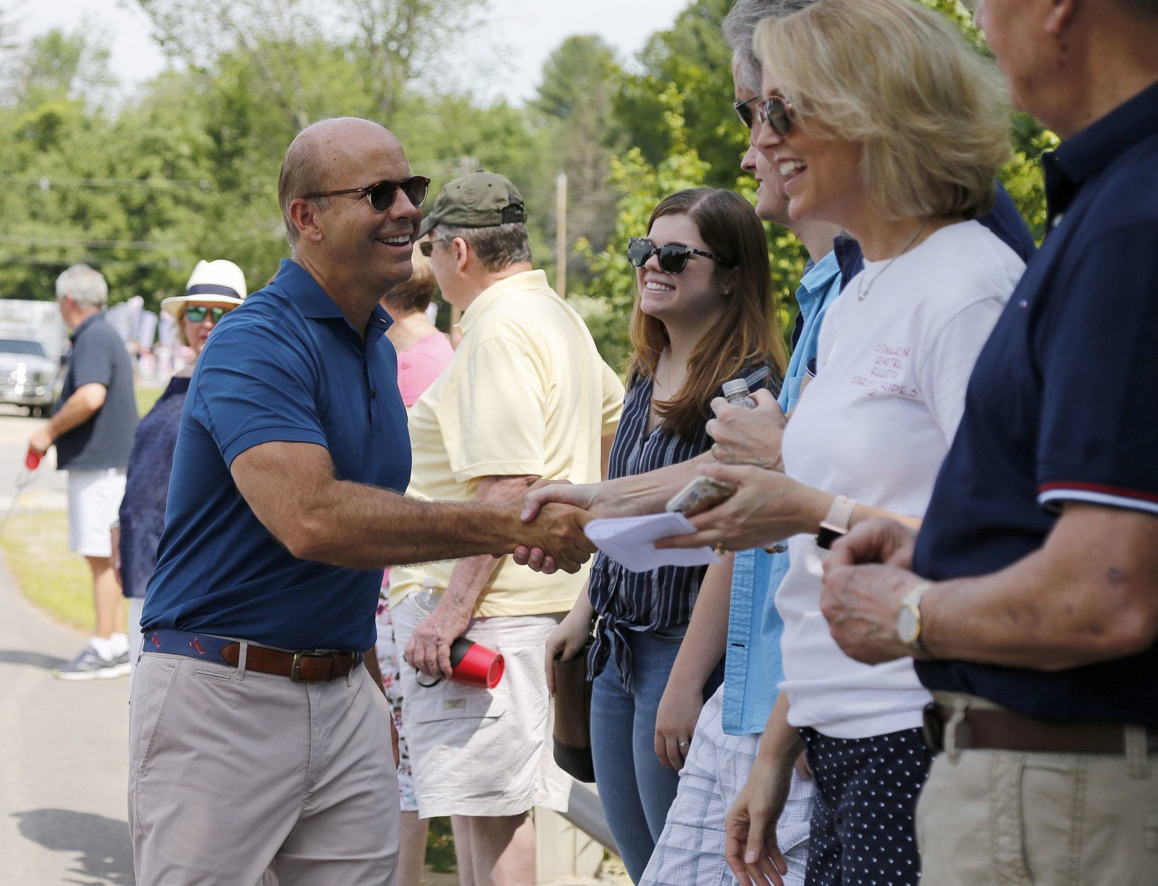 Democratic presidential candidate former U.S. Rep. John Delaney, D-Md., shakes hands with potential supporters along the route during the Fourth of July Parade, Thursday, July 4, 2019, in Amherst. (AP Photo/Mary Schwalm)