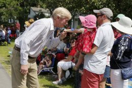 Republican presidential candidate former Massachusetts Gov. William Weld leans in to kiss the hand of Abigail Smith, 2, of Concord, Mass., along the route during the Fourth of July Parade, Thursday, July 4, 2019, in Amherst. (AP Photo/Mary Schwalm)