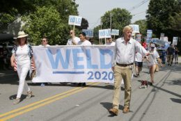 Republican presidential candidate former Massachusetts Gov. William Weld waves to potential supporters as he walks along the route with his wife Leslie Marshall during the Fourth of July Parade, Thursday, July 4, 2019, in Amherst. (AP Photo/Mary Schwalm)