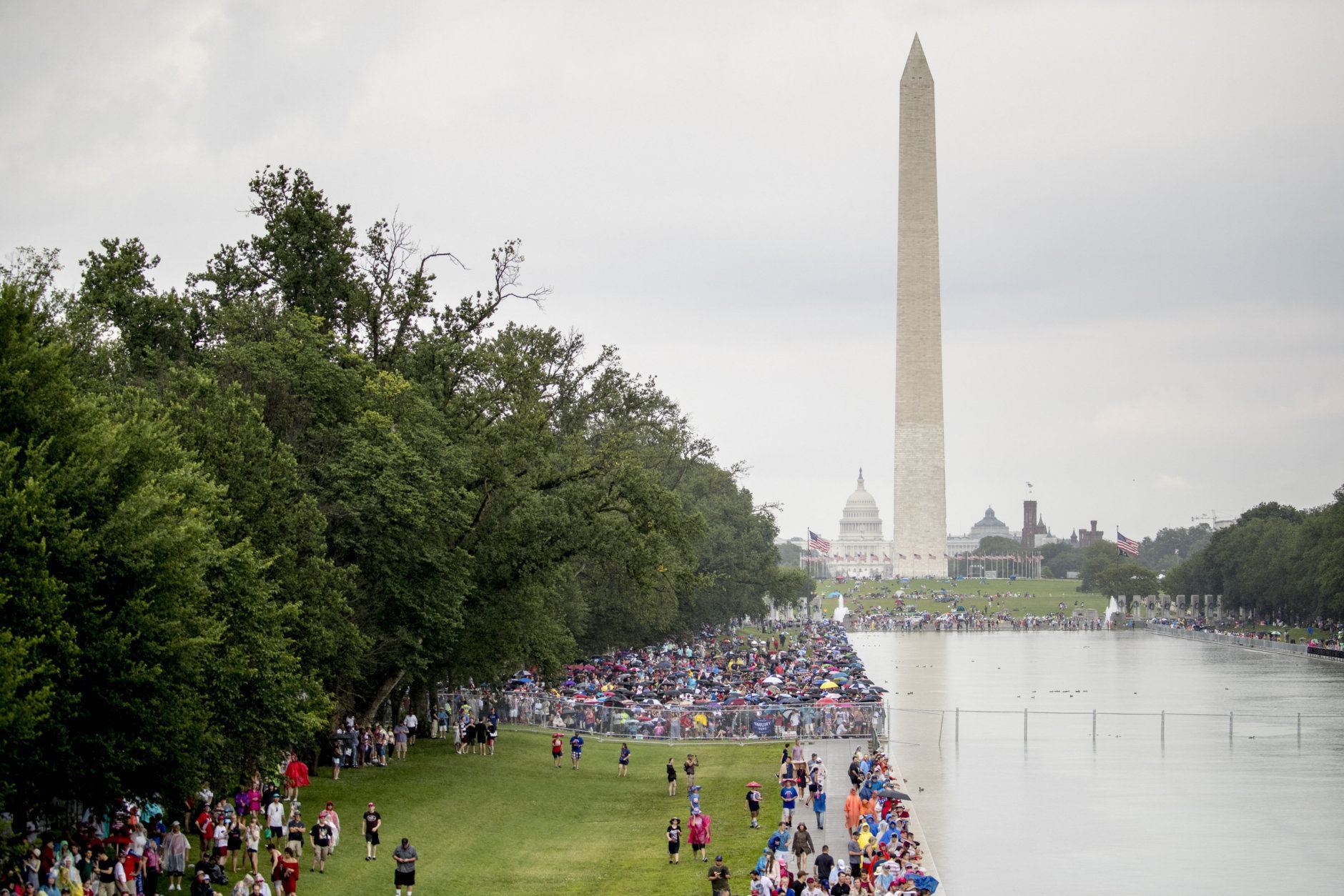 Crowds gather in the rain along the Reflecting Pool before President Donald Trump's 'Salute to America' event honoring service branches on Independence Day, Thursday, July 4, 2019, in Washington. President Donald Trump is promising military tanks along with "Incredible Flyovers &amp; biggest ever Fireworks!" for the Fourth of July. (AP Photo/Andrew Harnik)