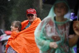 John Hood, back right, waits out rainfall alongside his wife, Kathy, before Independence Day celebrations, Thursday, July 4, 2019, on the National Mall in Washington. (AP Photo/Patrick Semansky)