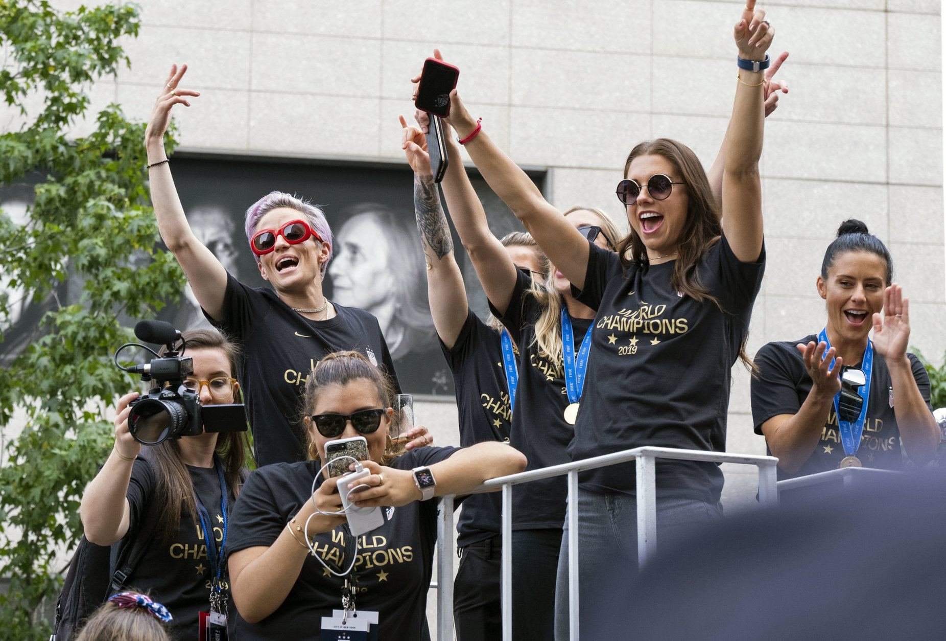 Members of the U.S. women's soccer team, including Megan Rapinoe, rear left, and Alex Morgan, right foreground, stand on a float before being honored with a ticker tape parade along the Canyon of Heroes in New York, Wednesday, July 10, 2019. The U.S. national team beat the Netherlands 2-0 to capture a record fourth Women's World Cup title. (AP Photo/Craig Ruttle)