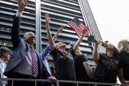 U.S. Soccer Federation president Carlos Cordeiro, left, U.S. women's soccer player Megan Rapinoe, center, and teammates celebrate the U.S. women's soccer team World Cup victory during a ticker tape parade along the Canyon of Heroes, Wednesday, July 10, 2019, in New York. (AP Photo/Craig Ruttle)
