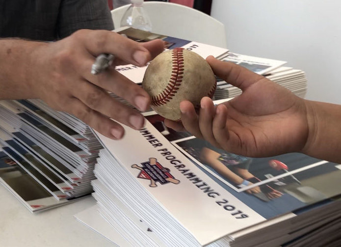 A Nats player autographs a baseball