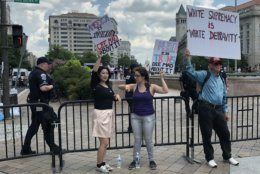 Counter protesters hold signs with Freedom Plaza behind them during demonstrations in D.C. on July 6, 2019. (WTOP/Michelle Basch)