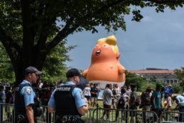 WASHINGTON, DC - JULY 04: People and police are seen in front of the Baby Trump balloon during the Fourth of July festivities on July 4, 2019 in Washington, DC. President Trump is holding a "Salute to America" celebration on the National Mall on Independence Day this year with musical performances, a military flyover, and fireworks. (Photo by Stephanie Keith/Getty Images)