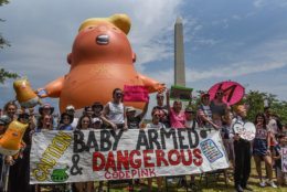 WASHINGTON, DC - JULY 04: People are seen in front of the Baby Trump balloon during the Fourth of July festivities on July 4, 2019 in Washington, DC. President Trump is holding a "Salute to America" celebration on the National Mall on Independence Day this year with musical performances, a military flyover, and fireworks. (Photo by Stephanie Keith/Getty Images)