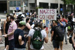 A protester opposing the far-right holds a sign against white supremacy in a counter-protest to a July 6, 2019 rally by far-right figures in Washington, D.C.’s Freedom Plaza. Trump supporters and anti-fascist organizers held dueling rallies across the street from each other, leading to high tensions as D.C. and U.S. Park Police largely held the peace. (WTOP/Alejandro Alvarez)