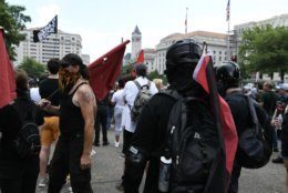 Far-left activists known as antifa wear helmets and dress in all black as they patrol Washington, D.C.’s 14th Street to confront supporters of President Donald Trump on July 6, 2019. Trump supporters and anti-fascist organizers held dueling rallies across the street from each other, leading to high tensions as D.C. and U.S. Park Police largely held the peace. (WTOP/Alejandro Alvarez)
