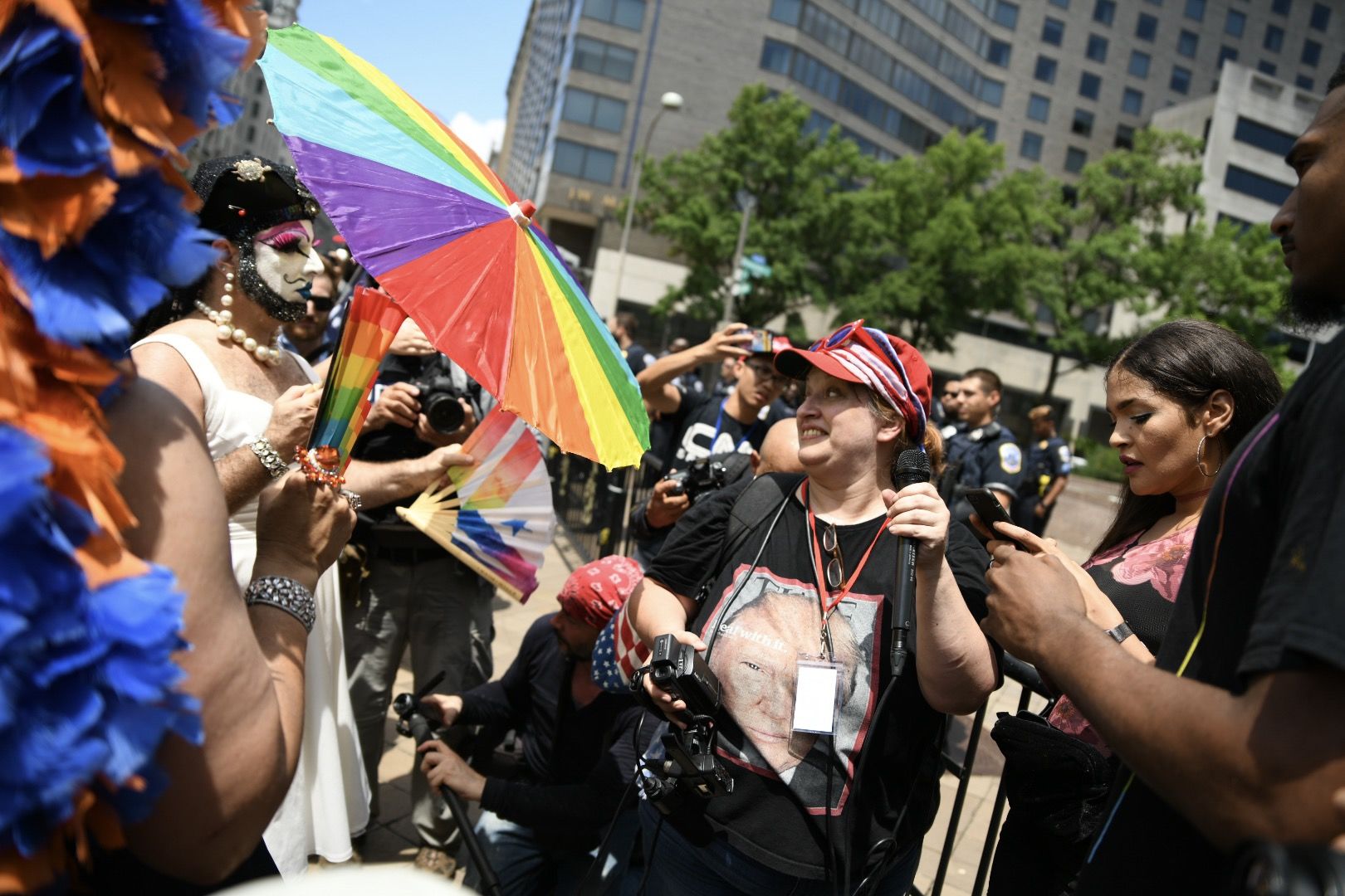 LGBTQ activists wave rainbow flags in an attempt to drown out a right-wing broadcast, seen lower right, during a far-right rally in Washington, D.C. on July 6, 2019. Trump supporters and anti-fascist organizers held dueling rallies across the street from each other, leading to high tensions as D.C. and U.S. Park Police largely held the peace. (WTOP/Alejandro Alvarez)