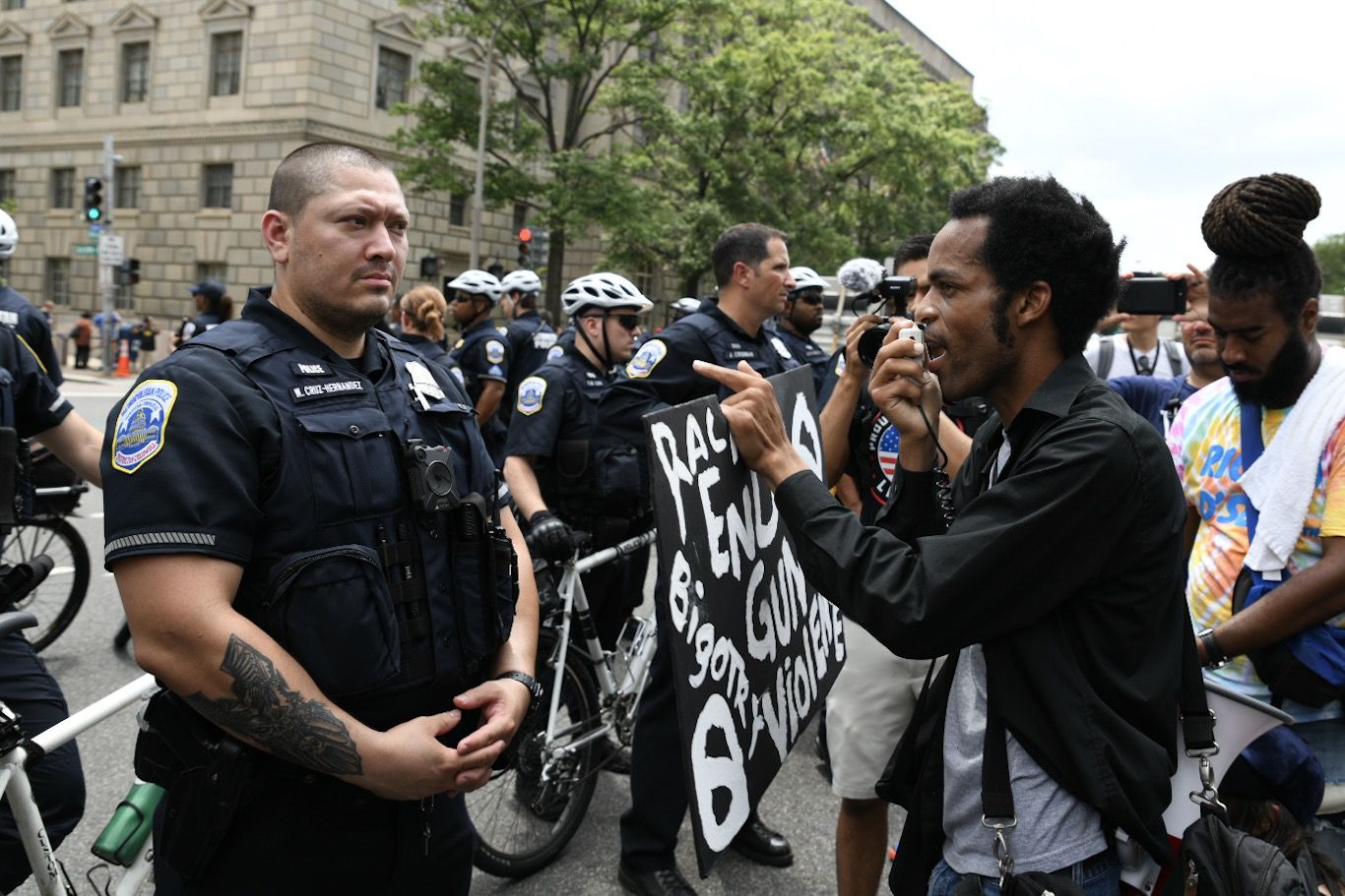 A protester confronts a Washington, D.C. police officer, accusing them of protecting white supremacists, while opposing a far-right rally on July 6, 2019. Trump supporters and anti-fascist organizers held dueling rallies across the street from each other, leading to high tensions as D.C. and U.S. Park Police largely held the peace. (WTOP/Alejandro Alvarez)