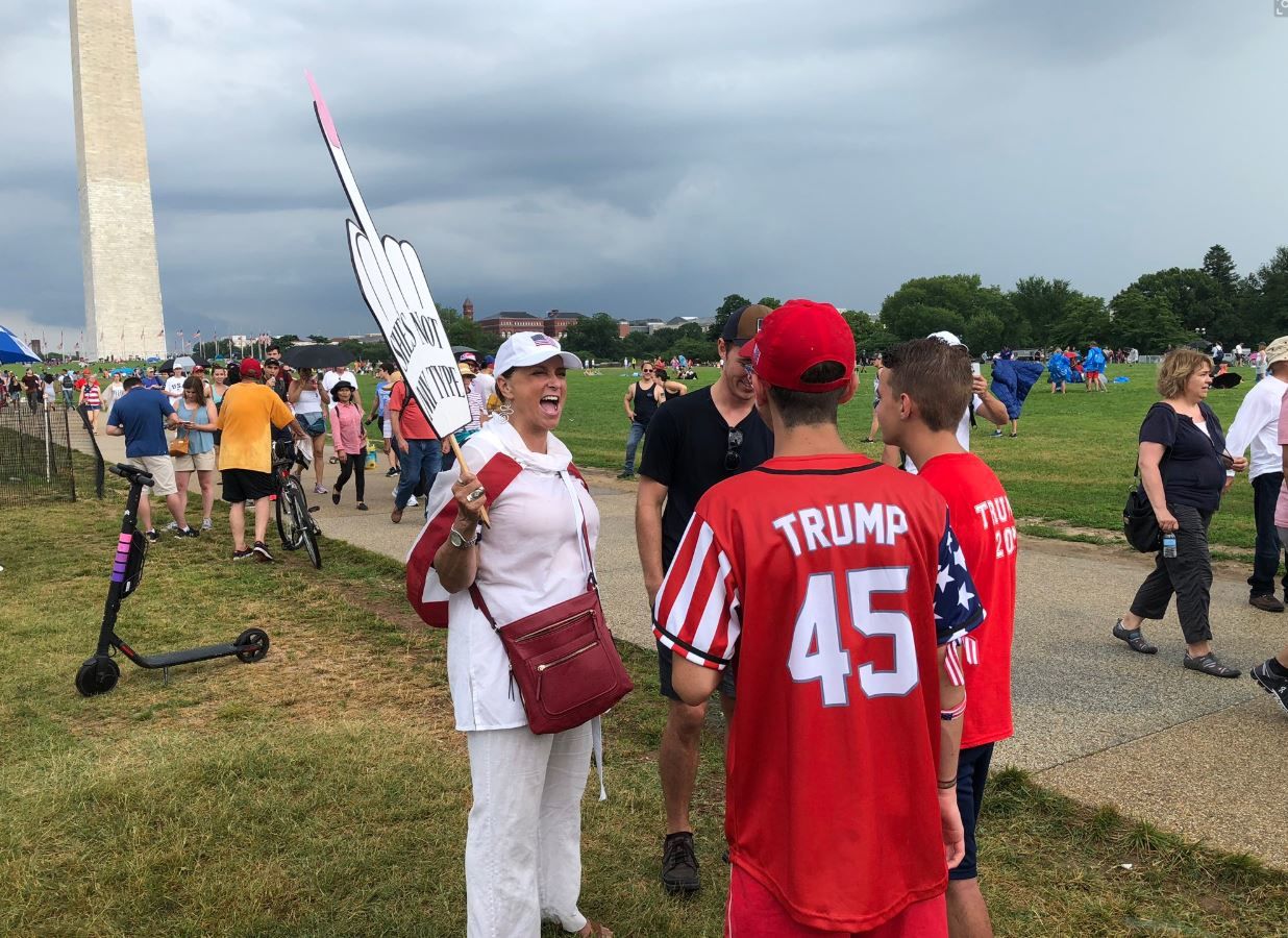 A protester and Trump supporters engage in a conversation during the July Fourth activities at the National Mall. (WTOP/Mike Murillo)
