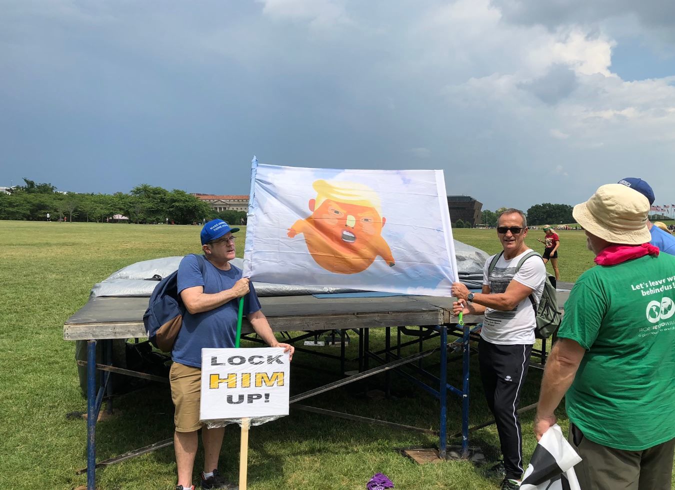 An inflatable image of President Donald Trump as a baby has been deflated, so protesters are using a flag image of it instead. (WTOP/Mike Murillo)