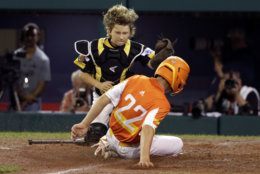 River Ridge, La.'s Reece Roussel (22) scores ahead of the tag by South Riding, Va.'s Noah Culpepper during the third inning of a baseball game at the Little League World Series in South Williamsport, Pa., Thursday, Aug. 22, 2019. (AP Photo/Gene J. Puskar)
