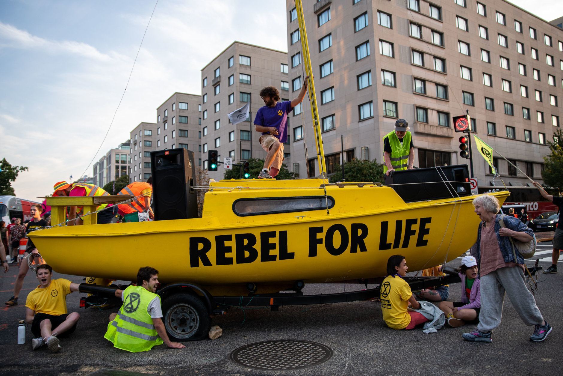 Protesters with Extinction Rebellion use a sailboat to block the intersection of K and 16th streets in downtown Washington, D.C. on Sept. 23, 2019. Environmental activists pressured lawmakers to declare a climate change emergency by paralyzing morning traffic in the nation's capital. (WTOP/Alejandro Alvarez)