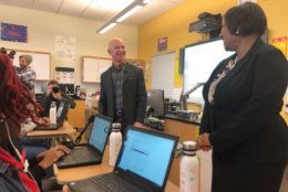 Amazon CEO Jeff Bezos shares a laugh with Dunbar computer science teacher Ramona Hutchins during his visit to her classroom. (WTOP/Melissa Howell)