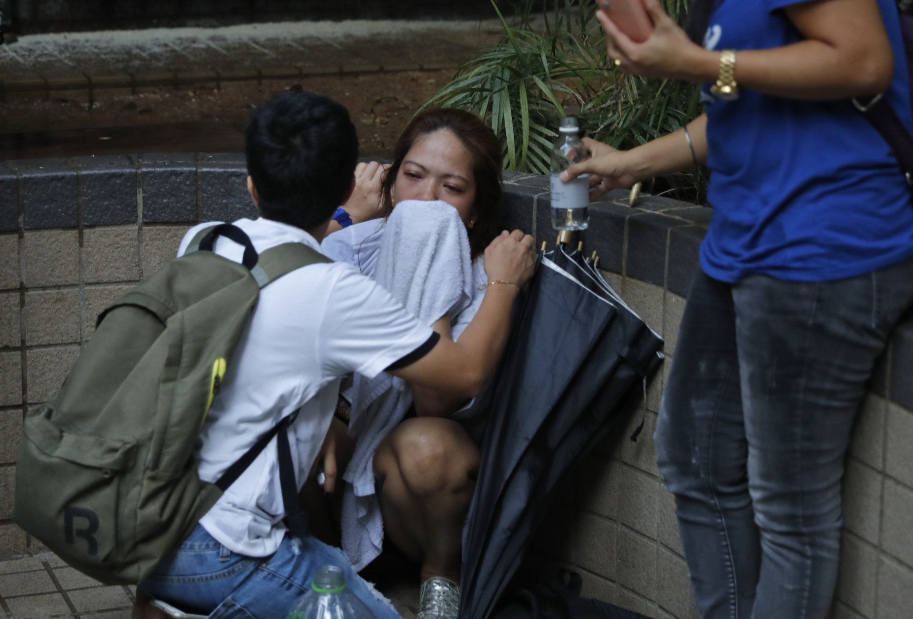 hong kong police help a woman affected by tear gas