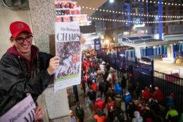 WASHINGTON, DC - OCTOBER 30: James Benner, a University of Georgetown student from Boston, holds up the front page of the Washington Post announcing the Washington Nationals victory for other Nationals fans as they stream into the streets from Nationals Park on October 30, 2019 in Washington, DC. The Washington Nationals defeated the Houston Astros 6-2 in Game 7 of the World Series bringing home the first World Series Championship in franchise history and the first to Washington, DC since 1924. (Photo by Samuel Corum/Getty Images)