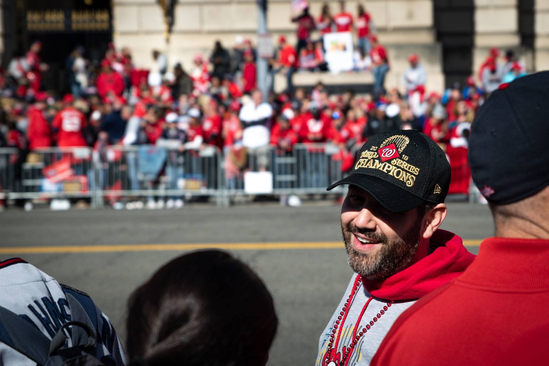 Nationals fans mingle along Constitution Avenue an hour prior to the beginning of the parade on a cold but sunny fall afternoon in downtown D.C. (WTOP/Alejandro Alvarez)