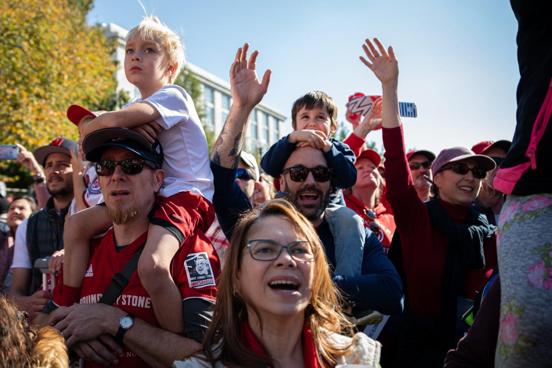 Nationals fans cheer the passing of the Commissioner's Trophy along Constitution Avenue. (WTOP/Alejandro Alvarez)