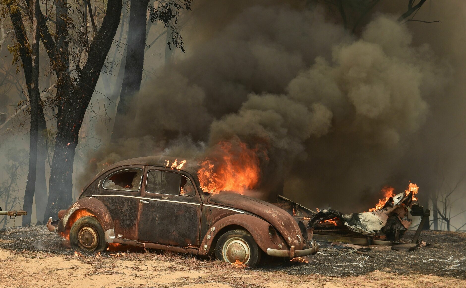 TOPSHOT - An old car burns from bushfires in Balmoral, 150 kilometres southwest of Sydney on December 19, 2019. - A state of emergency was declared in Australia's most populated region on December 19, as a record heat wave fanned unprecedented bushfires. (Photo by PETER PARKS / AFP) (Photo by PETER PARKS/AFP via Getty Images)