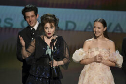 Helena Bonham Carter accepts the award for outstanding performance by an ensemble in a drama series for ""The Crown" at the 26th annual Screen Actors Guild Awards at the Shrine Auditorium &amp; Expo Hall on Sunday, Jan. 19, 2020, in Los Angeles. Looking on in background are Josh O'Connor and Erin Doherty. (Photo/Chris Pizzello)