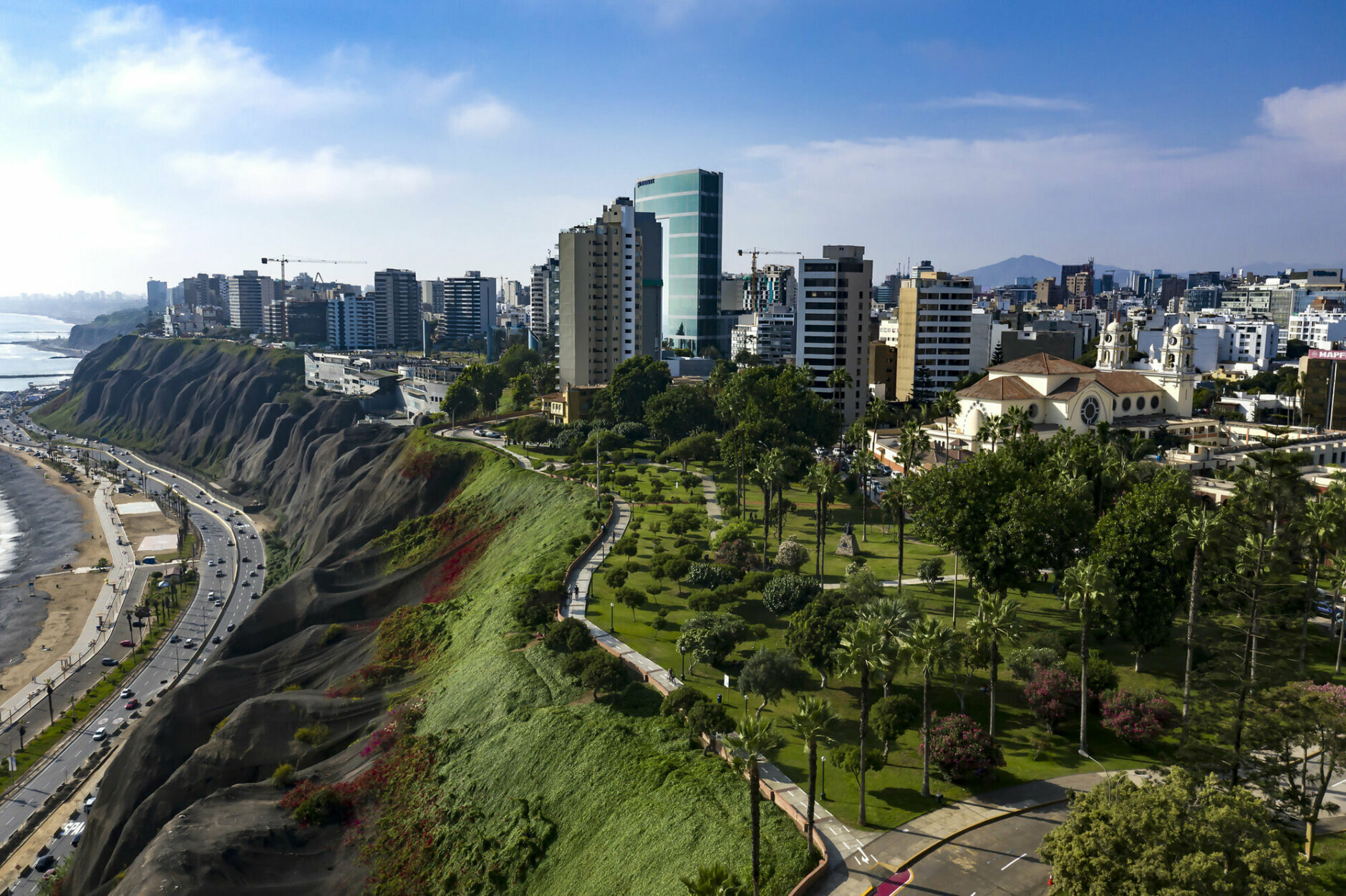 Aerial view of Miraflores shoreline including Domodossola park and Larcomar shopping mall. Clear and bright day, travel and destinations concept. Drone aerial shot of Lima's cityscape.