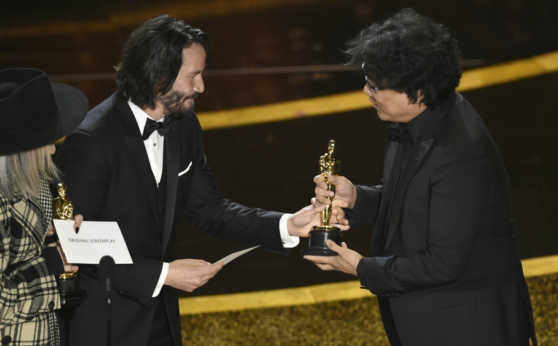 Diane Keaton, from left, and Keanu Reeves present the award for best original screenplay to Bong Joon Ho for "Parasite" at the Oscars on Sunday, Feb. 9, 2020, at the Dolby Theatre in Los Angeles. (AP Photo/Chris Pizzello)