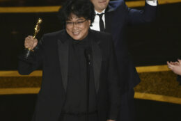 Bong Joon Ho, left, and Han Jin Won accept the award for best original screenplay for "Parasite" at the Oscars on Sunday, Feb. 9, 2020, at the Dolby Theatre in Los Angeles. (AP Photo/Chris Pizzello)