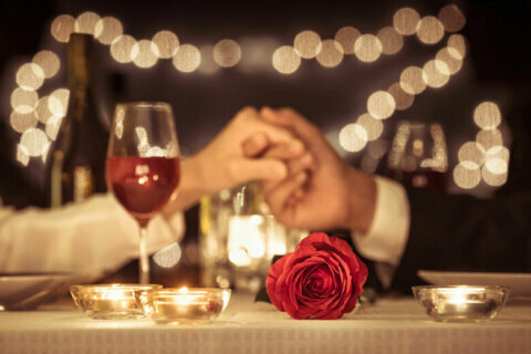 Couple holding hands having a romantic dinner date.