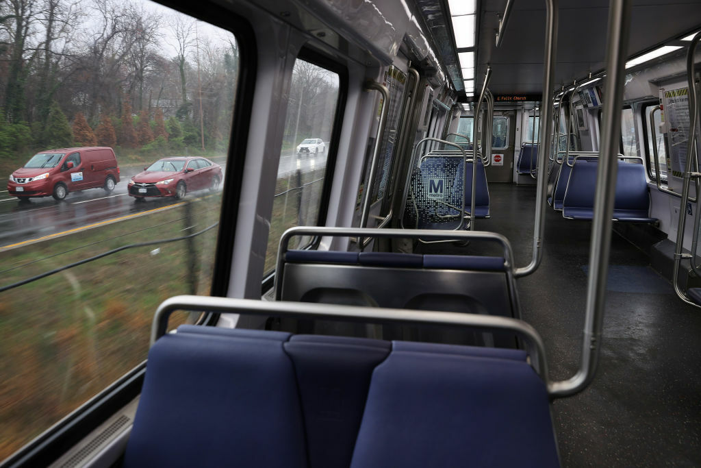 FALLS CHURCH, VA  - MARCH 25: Vehicles drive alongside an empty Silver Line train car as ridership across the Metro system is down nearly 90% because of the coronavirus pandemic March 25, 2020 in Falls Church, Virginia. 