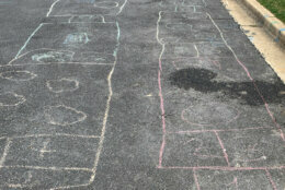 Hopscotch squares drawn in chalk on a neighboorhood street.