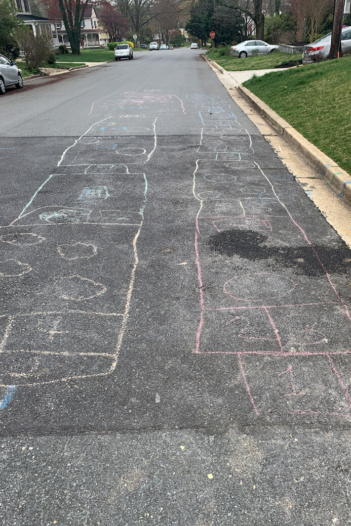 Hopscotch squares drawn in chalk on a neighboorhood street.