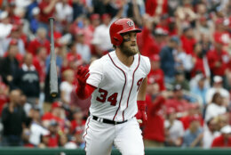 Washington Nationals' Bryce Harper flips his bat as he watches his solo home run during the sixth inning of an opening day baseball game against the Miami Marlins, at Nationals Park, Monday, April 3, 2017, in Washington. (AP Photo/Alex Brandon)