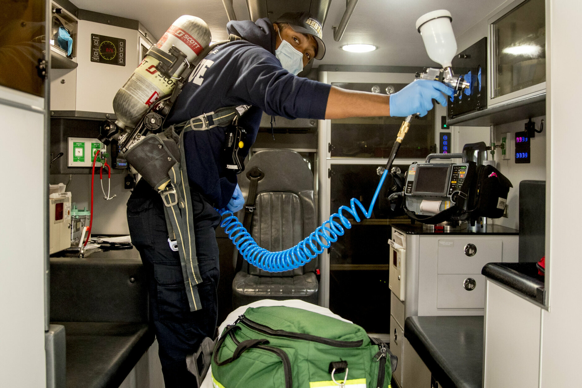 Volunteer EMT Ronald Felix, a full time police officer for Montgomery County, Md., sanitizes an ambulance at Bethesda-Chevy Chase Rescue Squad, Saturday, April 4, 2020, in Bethesda, a suburb of Washington. (AP Photo/Andrew Harnik)