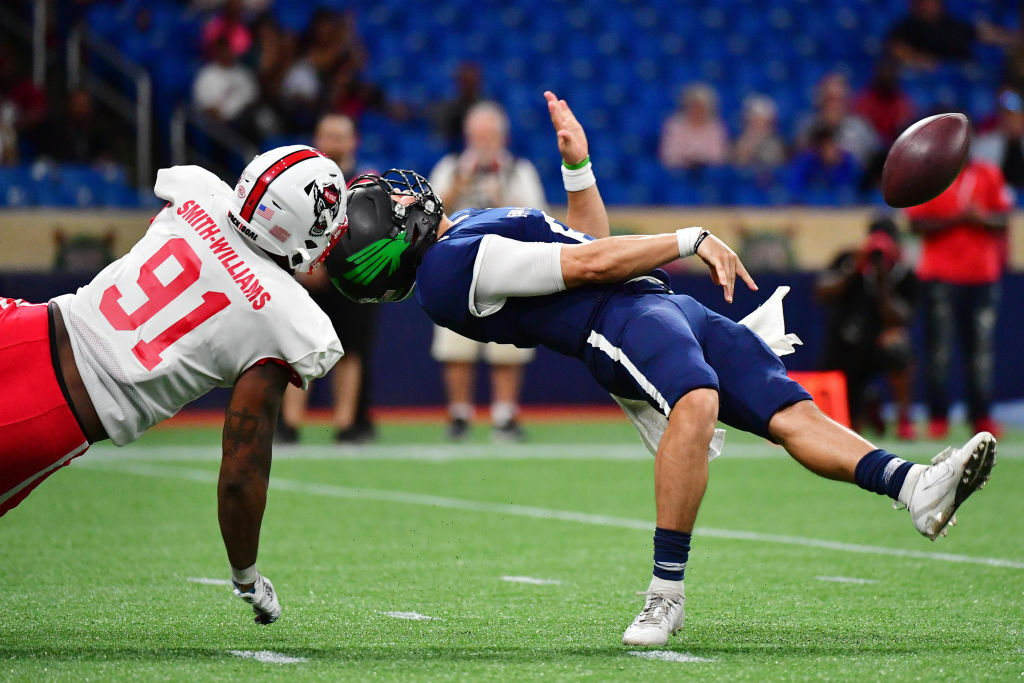 ST PETERSBURG, FLORIDA - JANUARY 18: Mason Fine #6 from North Texas playing for the West Team gets taken down by his face mask by James Smith-Williams #91 from North Carolina State playing for the East Team during the third quarter at the 2020 East West Shrine Bowl at Tropicana Field on January 18, 2020 in St Petersburg, Florida. (Photo by Julio Aguilar/Getty Images)