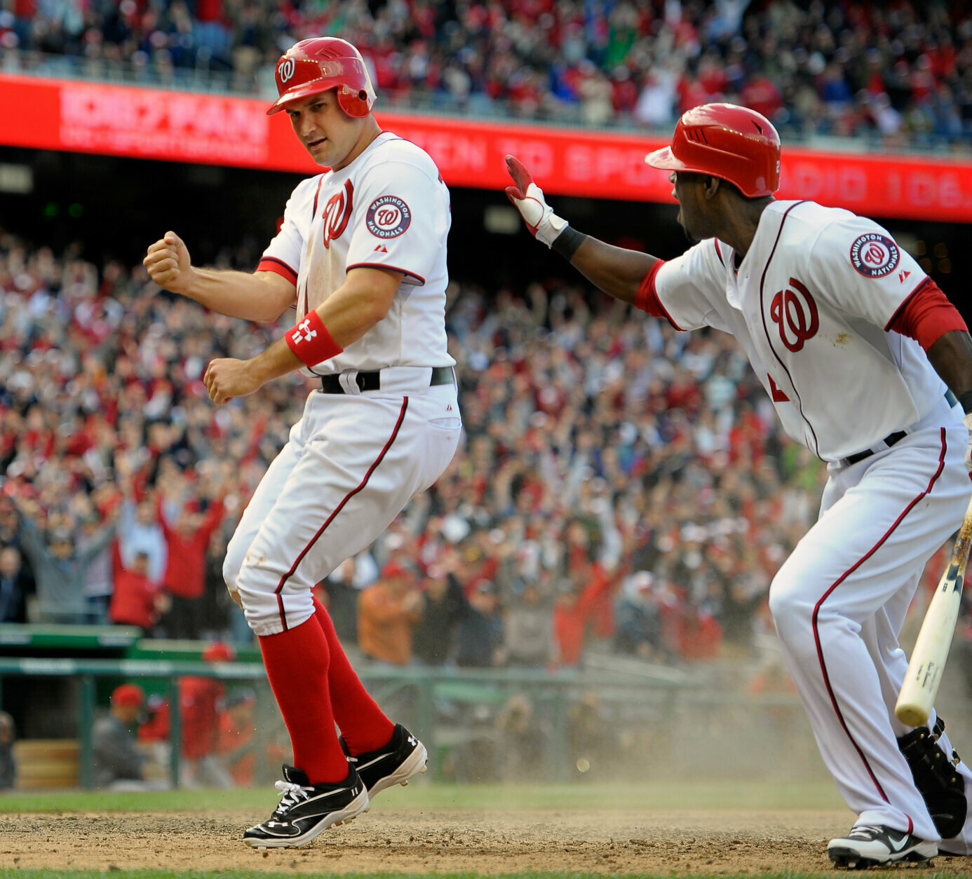 WASHINGTON DC, APRIL 12: Washington Nationals third baseman Ryan Zimmerman (11), left, celebrates after scoring the game winning run on a wild pitch in the 10th inning. Teammate Washington Nationals center fielder Roger Bernadina (2), right, was at bat during the Washington Nationals defeat of the Cincinnati Reds 3 - 2 going ten innings in their 2012 home opener at Nationals Stadium in Washington DC April 12, 2012 (Photo by John McDonnell/The Washington Post via Getty Images)