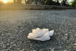 <p>An improperly discarded glove rests on a sidewalk near a playground during the pandemic. (WTOP/Dave Dildine)</p>
