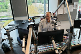 Male radio news anchor behind the mic, live on-air.n the WTOP traffic center.