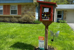 Photo of a little free library in front of a house.