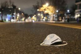 A discarded face mask rests a vacant stretch of Connecticut Avenue in Northwest D.C. (WTOP/Dave Dildine)